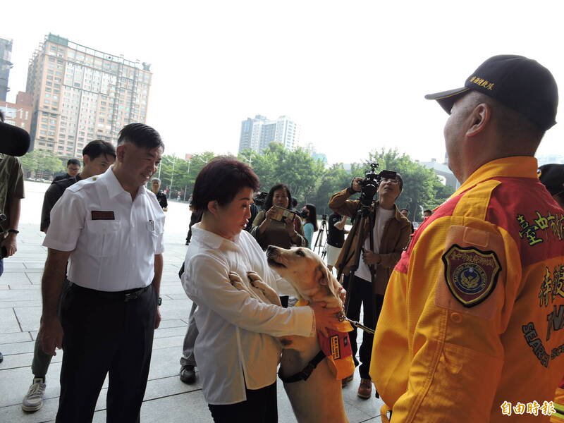 一只搜救犬扑向卢秀燕讨摸，卢秀燕一开始吓一跳，之后非常开心。（记者苏金凤摄）