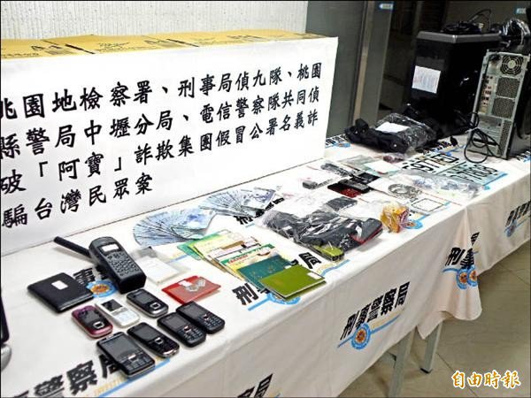 图为刑事局日前调查「阿宝」诈骗集团案，起出电脑主机、手机、存折与现金等赃证物。（记者黄敦砚摄）
