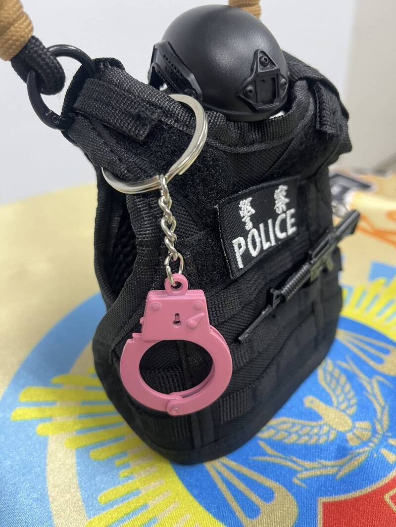 杯套以黑色战术风搭配粉红手铐与迷你冲锋枪吊饰。（小港分局提供）