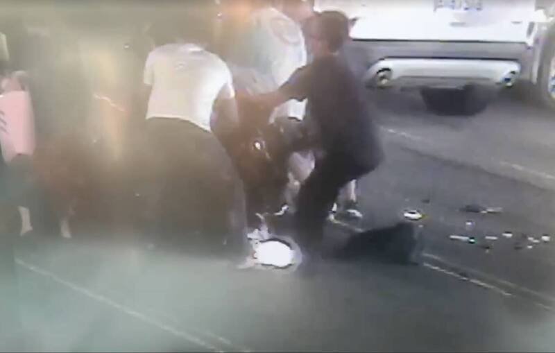 民众看到机车骑士卷入车底，赶紧上前抬车救人。（记者蔡淑媛翻摄）