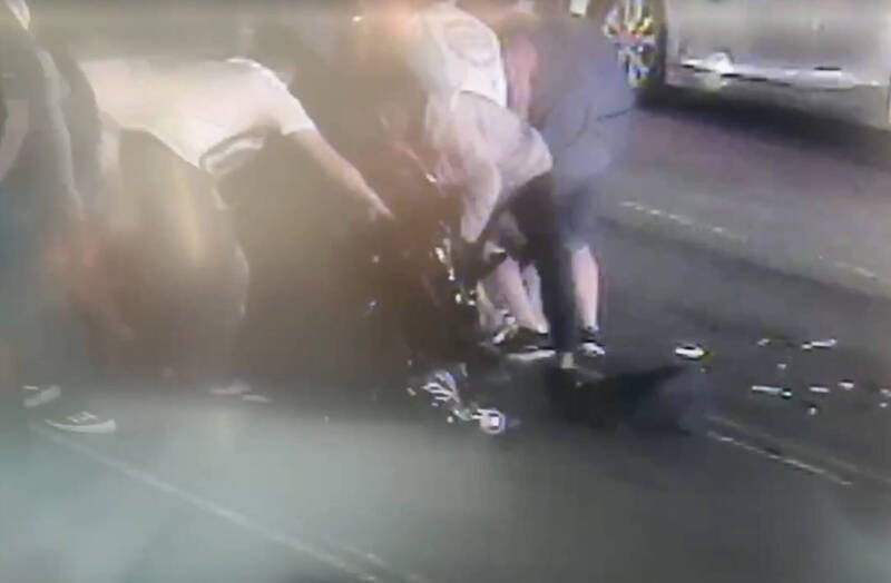 民众看到机车骑士卷入车底，赶紧上前抬车救人。（记者蔡淑媛翻摄）