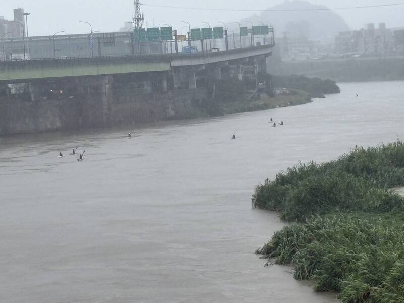 今日下午3时许，新北市消防局社后分队接获民众报案，指有多人无视豪雨在基隆河上划SUP。（民众提供）