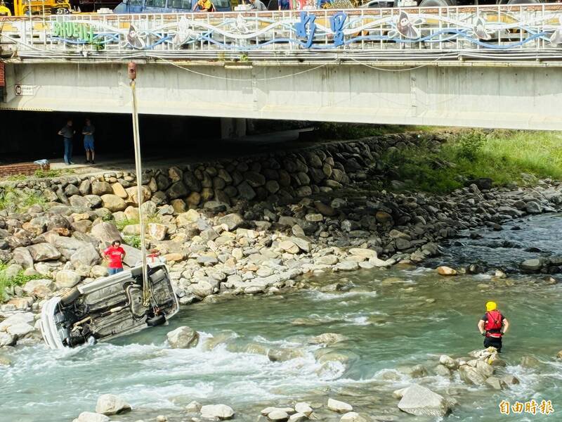 南投水里乡水里溪赫见汽车卡溪底，民众议论纷纷，消防署则解释是在进行洪灾演练。（记者刘滨铨摄）