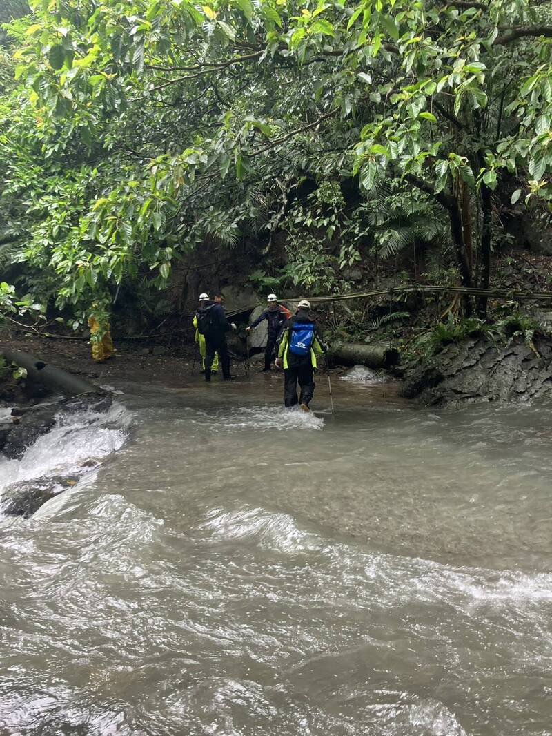 搜救队涉水寻找失联杨翁。（宜兰县消防局提供）