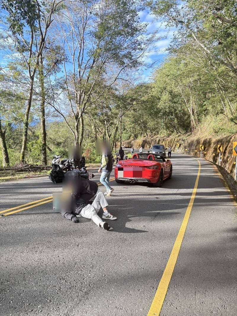 机车骑士摔落，其他机车骑士下来查看并协助。（仁爱警方提供）