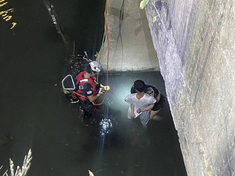 男友拥著腿部受伤的女友，2人由消防员救起。（民众提供）