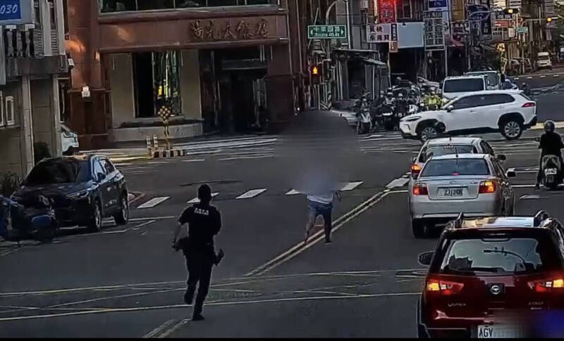 高雄李姓通缉犯拒检，警方自后追捕，他跳上友车撞警车，警对空鸣枪追捕逮人。（民众提供）