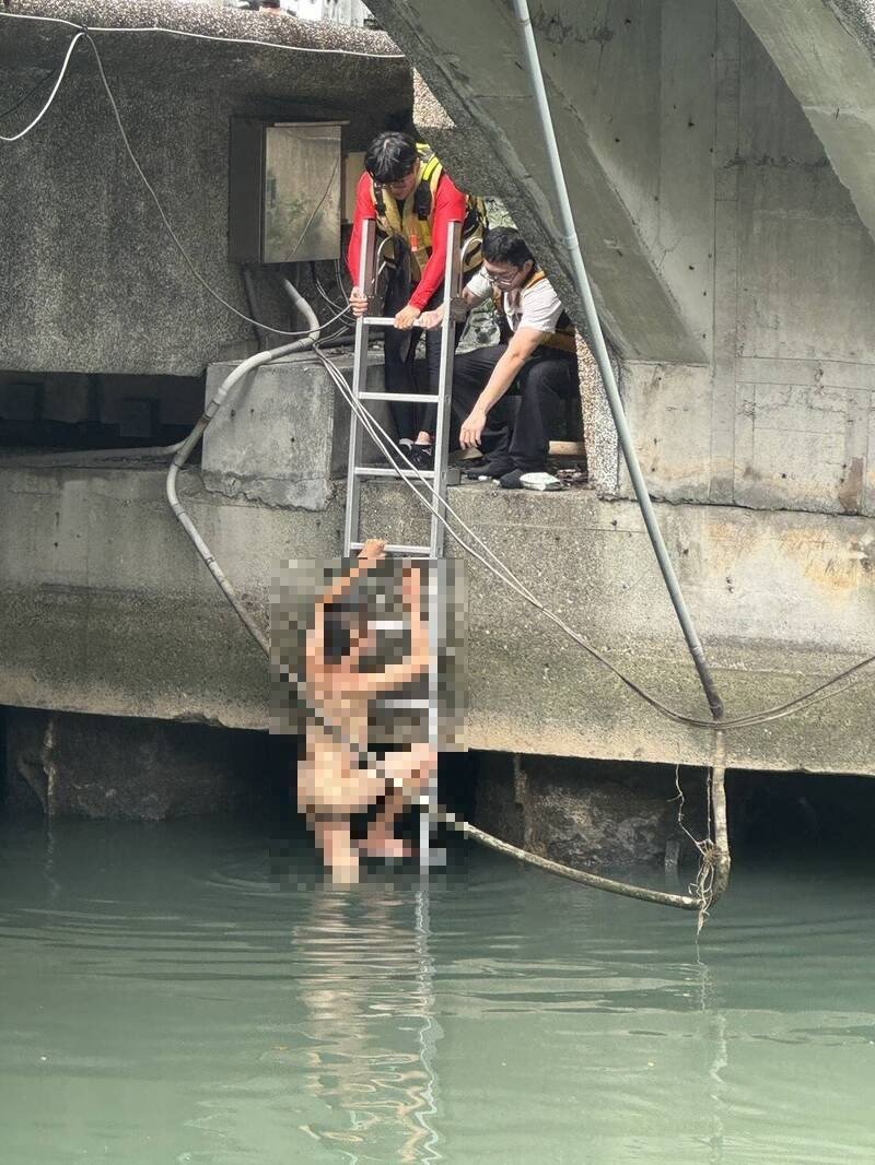 年约30岁男子跳入田寮河内，见消防队员前来救援，依指示攀梯上岸，全身光溜溜，引人侧目。（记者林嘉东摄）