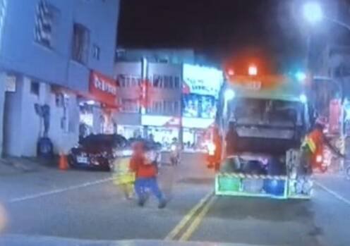 红色上衣的邱姓妇人倒完垃圾后，要穿越马路回去，与机车相撞。（取自《仁德生活圈》）