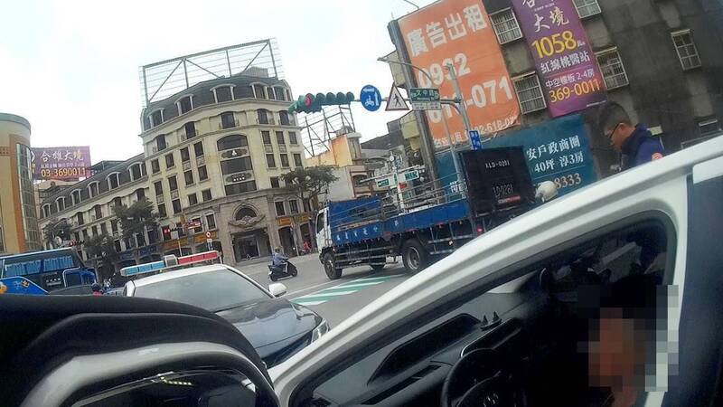 员警敲白色轿车车窗，叫醒手握毒品的邱姓男子（右）。（桃园市警察局提供）