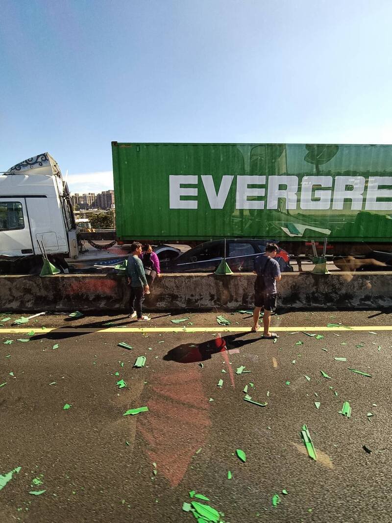 长荣货柜车行经国1中坜路段爆胎擦撞轿车、内侧护栏。（民众提供）