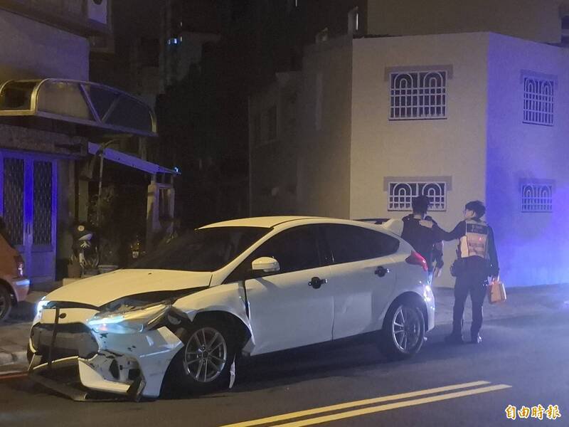 涉嫌酒驾男子情绪一度不稳，警方在旁安抚并实施酒测。（记者刘禹庆摄）