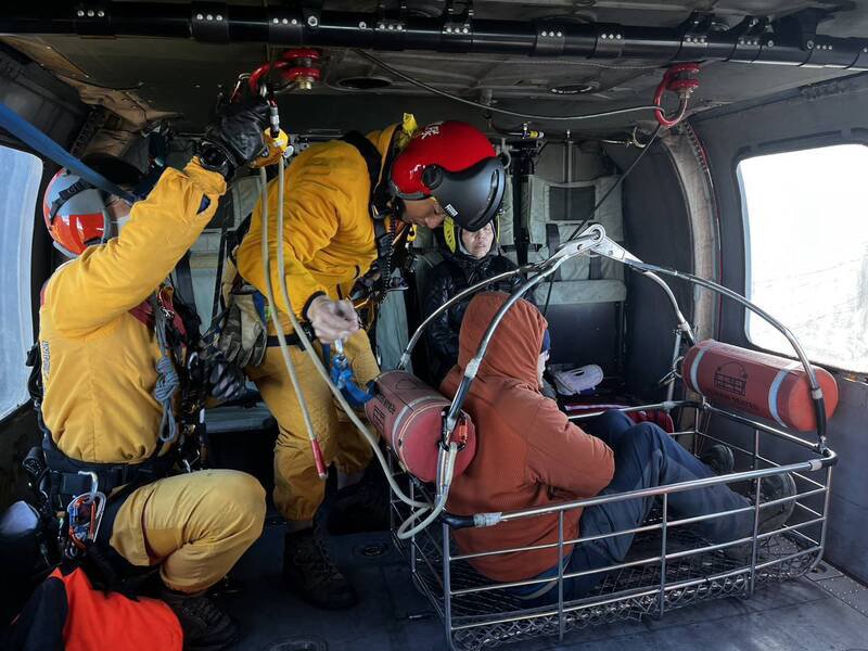 黑鹰直升机将邱男吊挂载下山。（民众提供）