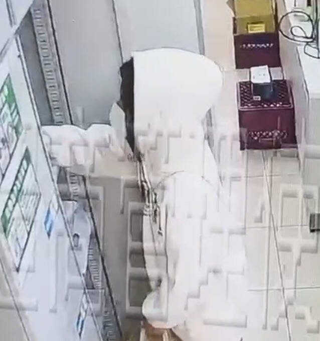 陈女趁店员不注意时，翻找包裹。（民众提供）