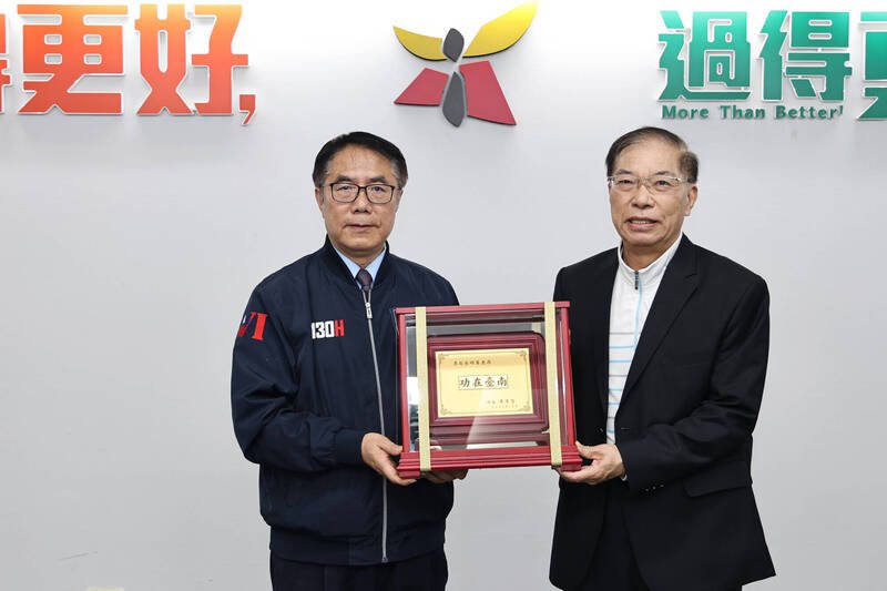 台南市长黄伟哲（左）向消防局前局长李明峰（右）致赠感谢纪念牌，感谢其贡献。（台南市府提供）