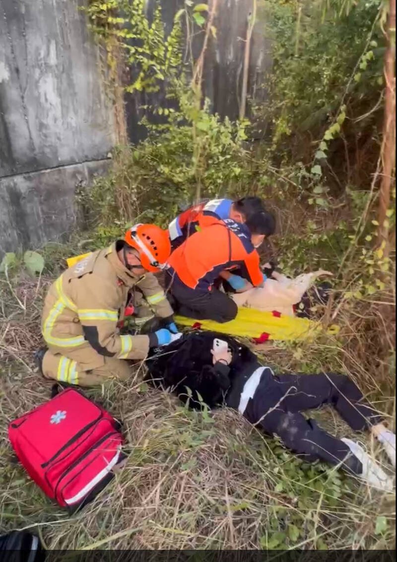 双载的女骑士与后座乘客自撞后摔落桥下，幸好杂草缓冲冲击力，消防人员抢送后将2人送医。（读者提供）
