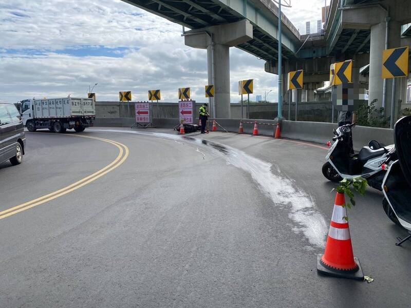 新北市五股一辆货车漏油，导致一名机车骑士摔车，警方到场维护交通。（记者吴仁捷翻摄）