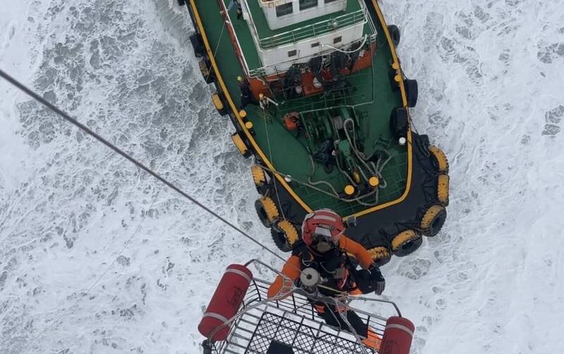 救援搁浅通鸿轮的台船接驳船，也被东北季风吹到搁浅，由空勤直升机将受伤等5名船员吊挂上岸。（空勤总队提供）