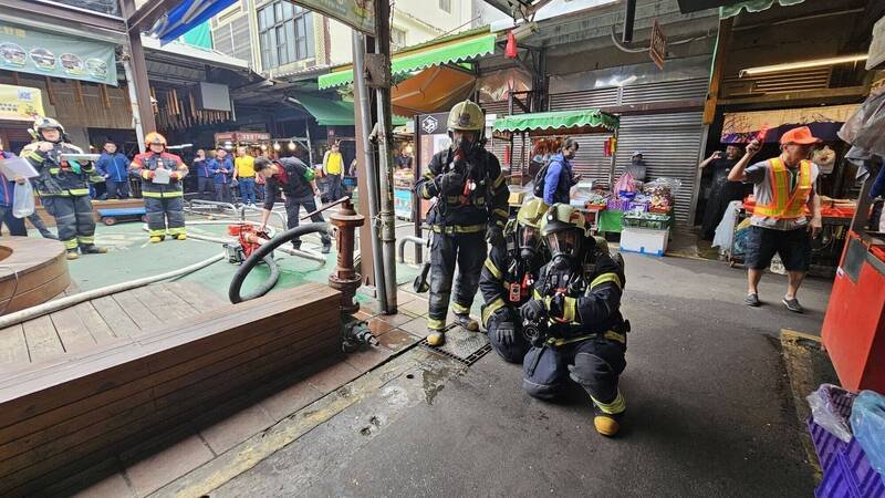 桃园市消防局第四大队选在龙潭传统市场举行火灾抢救兵棋推演暨摊商自卫消防编组演练。（桃市消防局提供）
