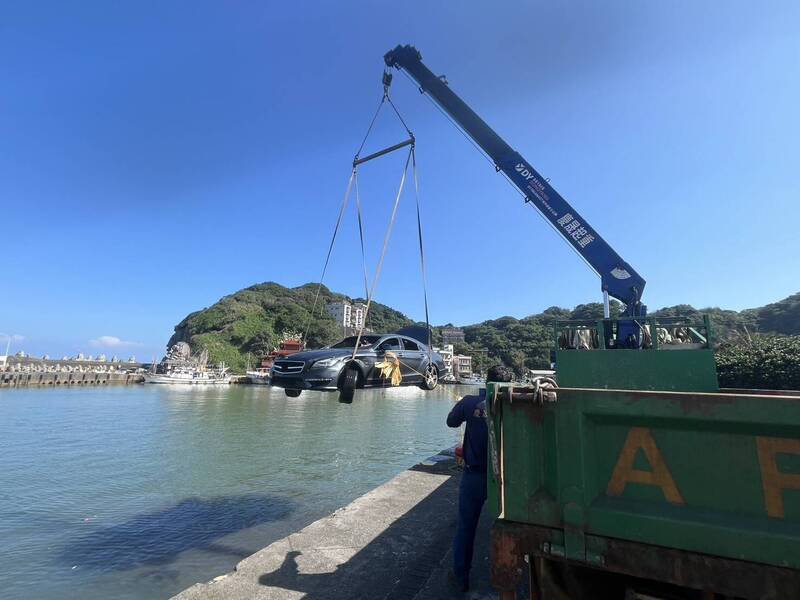 台北市1名陈姓女子24日凌晨驾车前往金山区访友途中，失控驶入新北市金山区磺港渔港，拖吊车将陈女轿车吊上岸。（记者林嘉东翻摄）