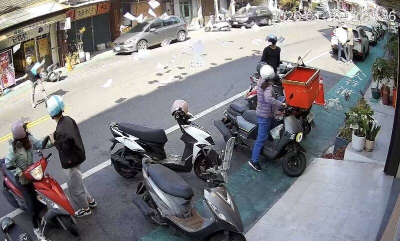 黑衣男子29日中午在便当店前朝空中散纸条，在场民众看傻了眼。（民众提供）