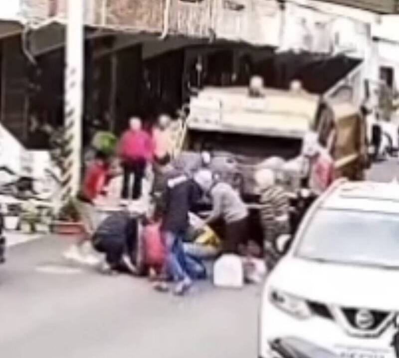 妇人往后跌倒，民众围上前关心。（撷取自「记者爆料网」脸书社群）