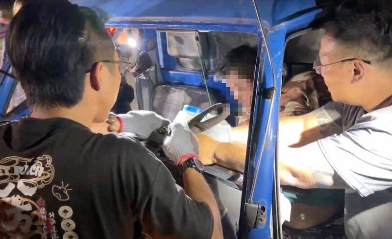 救难人员以拖吊车将变形的驾驶座拉开，驾驶方能脱困。（台湾国际紧急救难总队提供）
