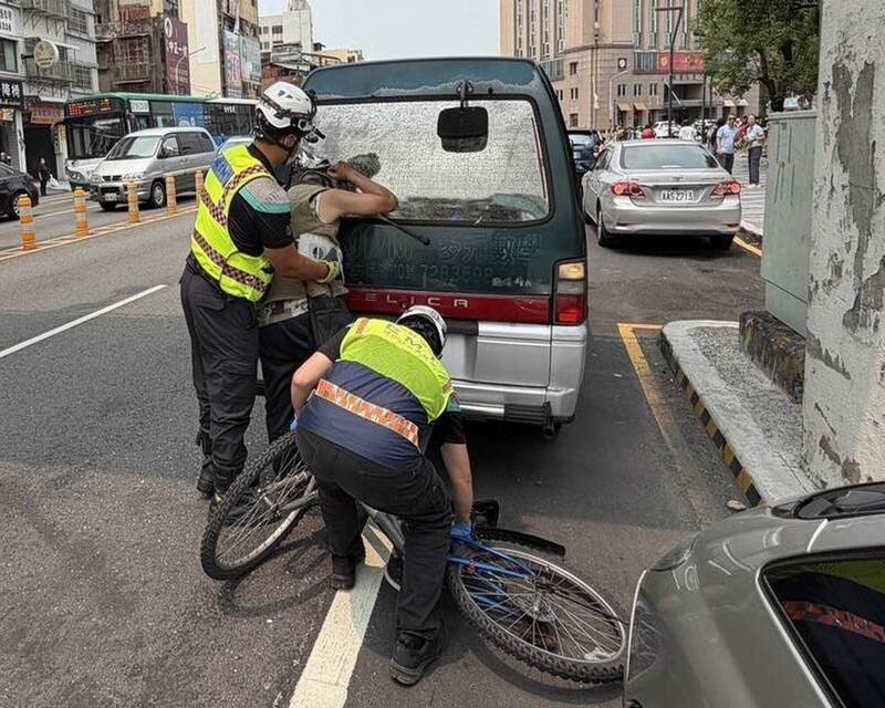 单车男撞破厢型车窗头卡玻璃，消防员拆玻璃抢救。（消防局提供）