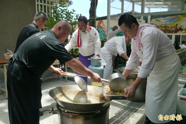 20多名厨师及志工自费、自假，轮流挤在安德幼儿园的狭小长廊上，挥汗准备近百人份的午餐。（记者王峻祺摄）