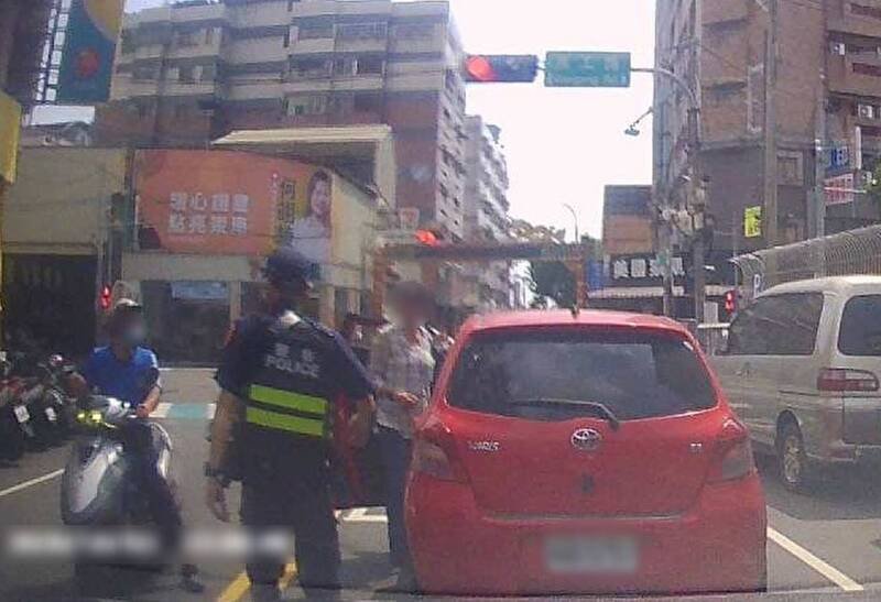 警方见红色轿车卡在路中，立即上前关心。（图由民众提供）