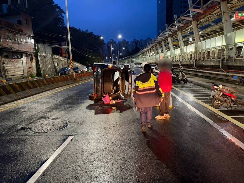 黄姓老翁驾车撞上中央分隔岛，车体90度侧翻，车内女乘客受伤。（记者吴升儒翻摄）